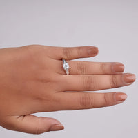 Hand wearing a diamond ring on a plain background, moissanite wedding ring, five stone anniversary ring