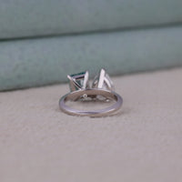 Silver ring with a green gemstone on a textured surface, White Pear & Green Radiant Moissanite Toi Et Moi Engagement Ring, Two Stone Moissanite Engagement Ring For Women