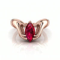 metalcolor:rose gold ring with a red gemstone on a white background