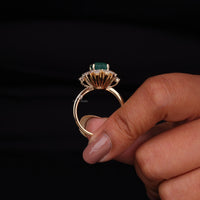 Gold ring with a green gemstone held by a hand against a black background, Elegant Green Emerald Cut CZ Stone Ring – 14K Yellow Gold Engagement & Wedding Band