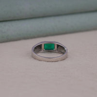 Silver ring with a green gemstone on a neutral background
