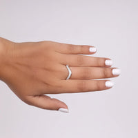 Hand wearing a silver ring with a white background, Chevron Enhancer Wedding Band, Curved CZ Stackable Ring, Contour Wedding Band for Her
