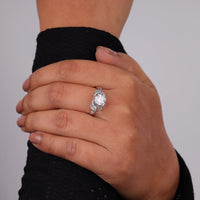 Hand wearing a diamond ring on a plain background, Round Brilliant Solitaire Engagement Ring – Dragonfly Inspired White Gold Ring