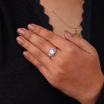 Hand wearing a diamond ring with a blurred background, Round Cut Solitaire Engagement Ring – Dragonfly Design White Gold Wedding Ring