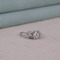 Silver ring with a large diamond on a light pink surface, White Gold Round Brilliant Solitaire Engagement Ring – Dragonfly Design Wedding Ring