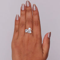 Hand wearing a diamond ring with glittery nail polish on a neutral background, Oval, Pear, Cushion and Round Moissanite Five Stone Wedding Ring – Unique Bridal Band