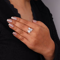 Hand wearing a diamond ring with a blurred background, Oval, Pear, Cushion & Round Moissanite Five Stone Ring – Unique Multi Shape Wedding Band