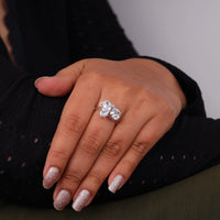 Hand wearing a silver ring with a clear gemstone against a neutral background, Five Stone Moissanite Ring – Oval, Pear, Cushion & Round Cut Multi Shape Wedding Band