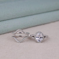 Silver ring with a diamond on a light background, Oval Halo Moissanite Engagement Ring Set – Split Shank Ring with Guard Wedding Band