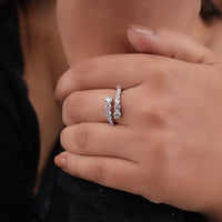 Close-up of a hand wearing two diamond rings on a blurred background, Moissanite ring for women, minimalist Moissanite ring, trendy Moissanite jewelry, alternative engagement ring, Moissanite stacking ring, adjustable Moissanite ring, graduated gemstone ring, statement Moissanite ring