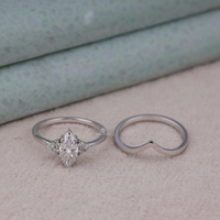 Two silver rings on a textured surface with a neutral background, Stackable Chevron Moissanite Wedding Band Set, Seven Stone Bridal Ring Set