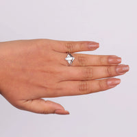 Hand wearing a silver ring with a diamond on a light gray background, Elegant Marquise & Round Moissanite Chevron Ring Set, Bridal Wedding Jewelry