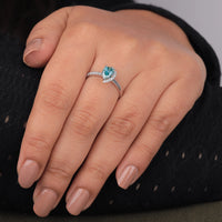 Hand wearing a silver ring with a blue gemstone on a dark background, Sustainable Moissanite Two Stone Ring, Conflict Free Moissanite Bridal Jewelry, Elegant Aqua Pear Engagement Ring