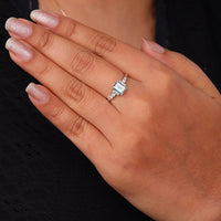Hand wearing a diamond ring with a black background