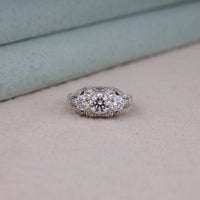 Diamond ring on a light gray surface with a neutral background, Unique Milgrain Engagement Ring For Brides, Timeless Round Moissanite Wedding Band