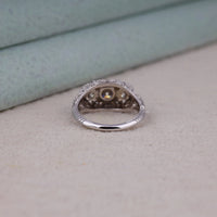 Silver ring with embedded stones on a textured surface, Eco Friendly Moissanite Engagement Jewelry, Heirloom Inspired Three Stone Wedding Ring