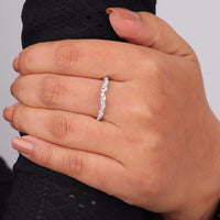 Hand wearing a diamond ring on a neutral background, Moissanite Milgrain Contour Wedding Band, Art Deco Leaf Inspired Design