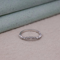 Silver ring with intricate design on a textured surface, Stackable Milgrain Leaf Contour Wedding Ring, Vintage Art Deco Moissanite Band