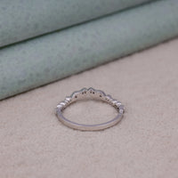 Silver ring on a beige surface with a neutral background, Art Deco Moissanite Anniversary Band, Classic Milgrain Wedding Ring For Women, 14K Gold Vintage Leaf Bridal Jewelry