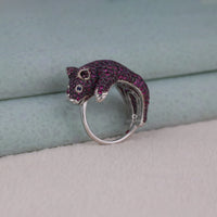 Silver ring with purple gemstone accents on a textured surface