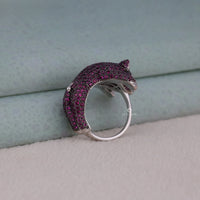 Silver ring with a purple gemstone design on a textured surface