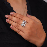 Hand wearing a silver ring with a black background, Contemporary Criss Cross Moissanite Engagement Ring, Sparkling Multi Band Moissanite Promise Ring