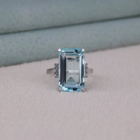 Ring with a large emerald-cut gemstone on a neutral background