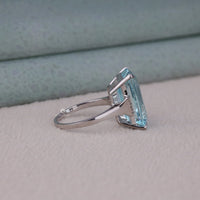 Silver ring with a large blue gemstone on a textured surface
