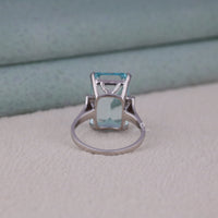 Silver ring with a blue gemstone on a textured surface