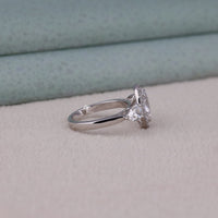 Silver ring with a large diamond on a light gray surface