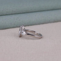 Silver ring with a diamond on a light gray surface