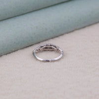 Silver ring on a light gray surface with a soft green background, sparkling Moissanite stone, romantic proposal ring, vintage style bridal ring, Moissanite jewelry for women, classic solitaire engagement ring, retro Moissanite ring, halo-free Moissanite design