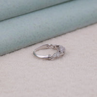 Silver ring with gemstones on a light gray surface, geometric Art Deco ring, ring with milgrain edges, simple Moissanite band, Moissanite ring gift, promise ring with Moissanite, bridal Moissanite ring, vintage inspired gemstone ring.