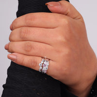 Hand wearing a silver ring with a pink gemstone on a plain background, Dainty Blush Pink & White CZ Band Set, Stackable Layering Rings for Gifts