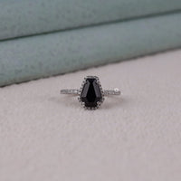Ring with a black gemstone on a light gray background