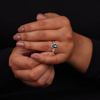 Close-up of hands with a ring on a black background