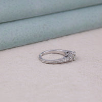 Silver ring with diamond accents on a light surface, Art Deco bridal ring, Moissanite wedding ring, milgrain engagement ring, round Moissanite bridal ring, vintage inspired Moissanite ring, Moissanite bridal set, Art Deco Moissanite ring, bridal jewelry with Moissanite, round cut Moissanite ring