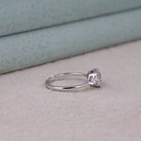 Silver ring with a diamond on a light wooden surface, Three Stone Wedding Ring – Asscher Cut Moissanite with Triangle Accent Stones