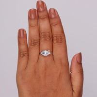 Hand wearing a diamond ring on a plain background, 14K Gold Three Stone Engagement Ring – Asscher Center with Triangle Moissanite Accents