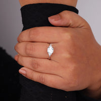 Hand wearing a diamond ring with a blurred background, Elegant Asscher & Triangle Cut Moissanite Ring – Three Stone Wedding Jewelry