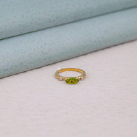 Gold ring with a green gemstone on a light gray background, east west marquise ring, peridot CZ engagement ring, marquise peridot ring, three stone engagement ring, past present future ring, green CZ engagement ring, east west set ring, marquise CZ ring, peridot wedding ring,