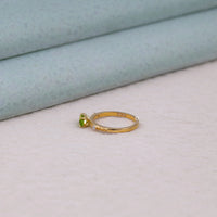 Gold ring with a green gemstone on a light fabric background,  peridot promise ring, marquise cut CZ ring, three stone CZ ring, east west bridal ring, green stone engagement ring, marquise peridot bridal ring, affordable engagement ring, unique engagement ring, colored stone ring
