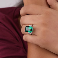 Close-up of a hand wearing an emerald ring with a blurred background, Green CZ Engagement Ring, Three Stone Emerald Cut Ring, Green White CZ Promise Ring
