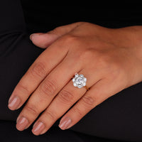 Close-up of a hand wearing a diamond ring on a black background