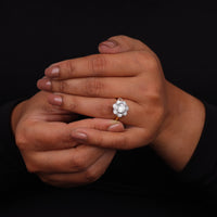 Hand wearing a diamond ring on a black background