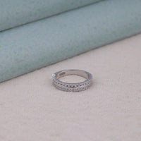 Silver ring with small stones on a light surface, Minimalist Moissanite Band Ethical Moissanite Jewelry