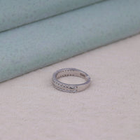 Silver ring with small stones on a light beige surface, Fine Gold Moissanite Ring, Elegant Moissanite Band for Her