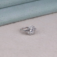 Silver ring with floral design on a light gray surface,  elegant Moissanite ring, Moissanite fine jewelry, timeless Moissanite ring, bezel setting engagement ring, vintage floral bridal ring, sparkling Moissanite floral ring, Moissanite statement ring, engagement ring with leaf motif