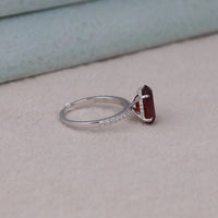 Silver ring with a red gemstone on a light surface, Red Garnet Oval CZ Stone Hidden Halo Engagement Ring, Oval Cut Red Garnet CZ Wedding Ring, Hidden Halo Garnet Inspired Bridal Ring