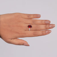 Hand wearing a ring with a red gemstone on a plain background, Dainty Hidden Halo Garnet Inspired Ring, 14K Gold Red Garnet CZ Wedding Jewelry,